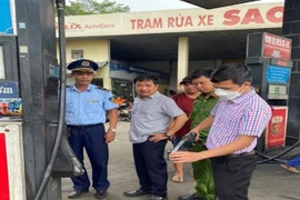Đoàn kiểm tra lấy mẫu xăng của doanh nghiệp kiểm tra và test nhanh. (Ảnh: TTXVN phát)