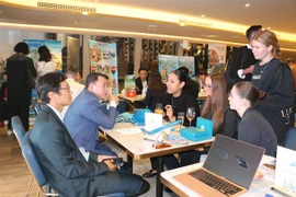 Đại diện Vietnam Airlines giới thiệu, quảng bá sản phẩm với khách tham dự sự kiện. (Ảnh: Thanh Tú/TTXVN)