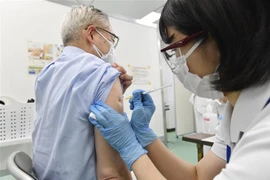 Nhân viên y tế tiêm vaccine phòng COVID-19 cho người dân tại Tokyo. (Ảnh: Kyodo/TTXVN)