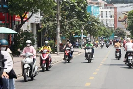 Người dân lưu thông bằng xe gắn máy trưa ngày 27/4 trên đường Hoàng Diệu, thành phố Thủ Đức. (Ảnh: Hồng Đạt/TTXVN)