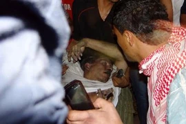 Người dân Libya cấp cứu một người đàn ông bất tỉnh được cho là đại sứ Mỹ tại Libya Chris Stevens trong khuôn viên lãnh sự quán Mỹ ở Benghazi sớm ngày 12/9. AFP/TTXVN