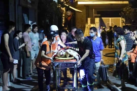 Đến 2h15, lực lượng chức năng tiếp tục đưa thêm 1 nạn nhân ra khỏi hiện trường. (Ảnh: Phạm Kiên/TTXVN)