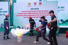 Hướng dẫn thực tập sử dụng bình cứu hỏa cá nhân dập tắt đám cháy tại các chung cư ở TP.HCM (Ảnh: Xuân Khu/TTXVN)