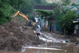 Tại Quốc lộ 7 đoạn qua bản Cầu Tám, xã Tà Cạ, huyện Kỳ Sơn, đất đá sạt xuống đường dày hơn 1m, tràn vào nhà dân 2 bên đường khiến giao thông tê liệt. (Ảnh: Văn Tý/TTXVN)