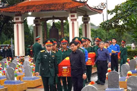 Đưa các hài cốt liệt sỹ về nơi an táng tại nghĩa trang liệt sỹ huyện Cam Lộ. (Ảnh:Nguyên Linh/TTXVN)