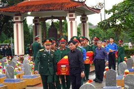 Đưa các hài cốt liệt sỹ về nơi an táng tại nghĩa trang liệt sỹ huyện Cam Lộ. (Ảnh:Nguyên Linh/TTXVN)
