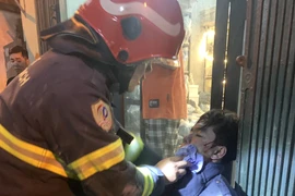 Các nạn nhân được cứu khỏi đám cháy. (Ảnh: Vietnam+)