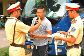 Lực lượng Cảnh sát giao thông huyện Nho Quan kiểm tra nồng độ cồn với lái xe. (Ảnh: Minh Đức/TTXVN)