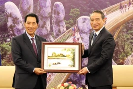 Bí thư Thành ủy Đà Nẵng Trương Quang Nghĩa tặng quà Phó Chủ tịch Quốc hội Lào Bounpone Bouttanavong. (Ảnh: Nguyễn Sơn/TTXVN)