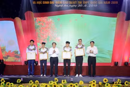 Ông Nguyễn Xuân Thắng, Chủ tịch Hội đồng lý luận Trung ương, Giám đốc Học viện Chính trí quốc gia Hồ Chí Minh, và ông Nguyễn Đắc Vinh, Bí thư Tỉnh ủy Nghệ An tặng Bằng khen cho bốn học sinh đạt thành tích cao trong các kỳ thi Quốc tế và khu vực. (Ảnh: Bíc