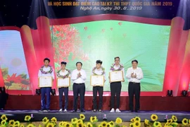 Ông Nguyễn Xuân Thắng, Chủ tịch Hội đồng lý luận Trung ương, Giám đốc Học viện Chính trí quốc gia Hồ Chí Minh, và ông Nguyễn Đắc Vinh, Bí thư Tỉnh ủy Nghệ An tặng Bằng khen cho bốn học sinh đạt thành tích cao trong các kỳ thi Quốc tế và khu vực. (Ảnh: Bíc