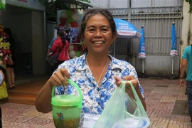 Người nhà bệnh nhân nhận suất ăn miễn phí từ Bếp yêu thương. (Ảnh: Đinh Hằng/TTXVN)