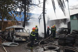 Lực lượng chức năng nỗ lực dập tắt một đám cháy. (Ảnh: Công Mạo/TTXVN)