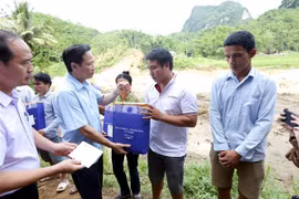 Bộ trưởng Bộ Lao động-Thương binh và Xã hội Đào Ngọc Dung tặng quà các gia đình bị thiệt hại nặng nề do ảnh hưởng mưa lũ tại bản Sa Ná, xã Na Mèo, huyện Quan Sơn có người thân bị chết, mất tích. (Ảnh: Anh Tuấn/TTXVN)