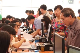 Thay vì phải tự đi nộp thuế tại kho bạc, hộ kinh doanh có thể thực hiện nghĩa vụ của mình qua các doanh nghiệp viễn thông, điện lực. (Ảnh: PV/Vietnam+)