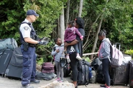 Cảnh sát Hoàng gia Canada kiểm tra một gia đình người tị nạn Haiti vào Canada từ Champlain, New York. (Nguồn: Reuters/TTXVN)