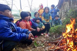 Học sinh trường tiểu học Yên Lạc, huyện Nguyên Bình (Cao Bằng) co ro bên đống lửa. (Ảnh: Quốc Đạt/TTXVN)