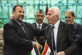 Trưởng đoàn đàm phán của Hamas, ông Saleh al-Aruri (trái) và Trưởng đoàn đàm phán của Fatah, ông Azzam al-Ahmad (phải) sau lễ ký thỏa thuận hòa giải tại Cairo, Ai Cập ngày 12/10. (Nguồn: AFP/TTXVN)