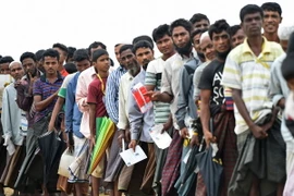 Người tị nạn Rohingya xếp hàng chờ nhận cứu trợ tại trại tị nạn Nayapara ở Teknaf, Bangladesh. ((Nguồn: AFP/TTXVN)