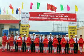 Đại biểu thực hiện nghi thức cắt băng khánh thành Trạm biến áp 220kV Long Xuyên 2 và đường dây đấu nối. (Ảnh: Công Mạo/TTXVN)