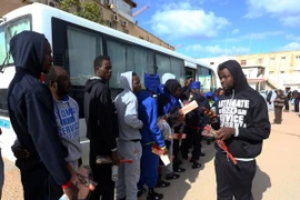 Người di cư lên xe buýt chuẩn bị hồi hương tại Tripoli, Libya. (Nguồn: THX/TTXVN)