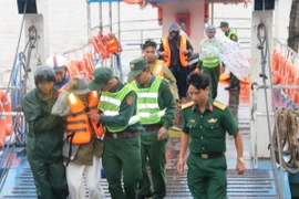 Lực lượng bộ đội tỉnh Trà Vinh hướng dẫn, giúp đỡ dân di tản về đất liền. (Ảnh: Phúc Sơn/TTXVN)