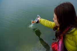 [Photo] Người dân Hà Nội đội mưa thả cá tiễn ông Táo về trời