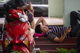 Nhiều phụ huynh vạ vật trước điểm thi Đại học Quốc gia để chờ con, em mình thi xong.