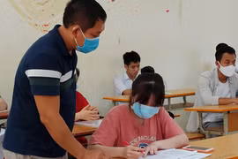 Lần đầu tiên trong lịch sử, học sinh và giám thị phải mang khẩu trang vào phòng thi vì dịch COVID-19. (Ảnh: Phạm Mai/Vietnam+)