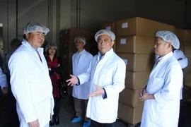 Đại sứ Đoàn Xuân Hưng (trái) thăm xưởng chế biến của Công ty Lehop. (Ảnh: Mạnh Hùng/Vietnam+)