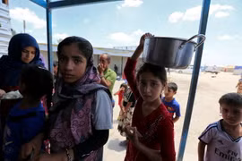 Trẻ em Iraq xếp hàng nhận lương thực cứu trợ tại khu vực Dora, ngoại ô thủ đô Baghdad ngày 31/5. (Nguồn: AFP/TTXVN)