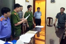 Công an đọc lệnh bắt tạm giam đối với ông Bùi Hoàng Hiền. (Ảnh: Đoàn Minh Huệ/Vietnam+)