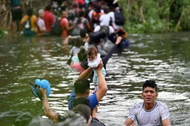 Người di cư từ Matamoros, bang Tamaulipas (Mexico) vượt sông Rio Grande để tìm cách vào Mỹ. (Ảnh: AFP/TTXVN)