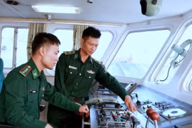 Thiếu tá Khúc Ngọc Minh cùng đồng đội kiểm tra kỹ thuật phương tiện chuẩn bị tuần tra kiểm soát trên biển. (Ảnh: Minh Thu/TTXVN)