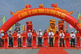 Phó Thủ tướng Lê Minh Khái, lãnh đạo các bộ, ngành Trung ương và lãnh đạo địa phương thực hiện nghi thức thông xe cầu Ông Đốc. (Ảnh: Huỳnh Anh/TTXVN)