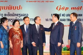 Chủ tịch Quốc hội Vương Đình Huệ, Chủ tịch Quốc hội Lào Saysomphone Phomvihane và đại biểu với các thế hệ lưu học sinh và cán bộ, giáo viên Trường Hữu nghị T78. (Ảnh: Doãn Tấn/TTXVN)