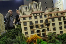 Các nhà đầu tư bất động sản tìm hiểu tình hình tại một triển lãm ở Bắc Kinh. (Ảnh: AFP/TTXVN)