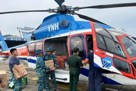 Vận chuyển hàng cứu trợ lên trực thăng tại sân bay Gia Lâm (Hà Nội). (Ảnh: Thông tấn Quân sự/TTXVN phát)
