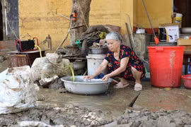 Người dân sinh sống trên 2 tuyến phố Thanh Niên và Trần Hưng Đạo, thành phố Yên Bái, dần trở lại cuộc sống thường nhật cho dù đường vẫn còn chưa hết ngập, chiều ngày 14/9. (Ảnh: Tuấn Anh/TTXVN)