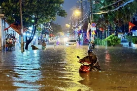Đến gần 20 giờ, đường Bình Chiểu, thành phố Thủ Đức vẫn lênh láng nước. (Ảnh: Hồng Giang/TTXVN)