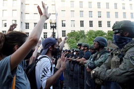 Cảnh sát được triển khai để ngăn người biểu tình quá khích trong cuộc tuần hành phản đối hành động của cảnh sát dẫn đến cái chết của người da màu George Floyd, tại Washington, DC. (Ảnh: AFP/TTXVN)