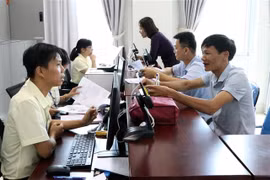 Cán bộ tiếp nhận hồ sơ, giải quyết thủ tục hành chính. (Ảnh: Việt Hoàng/TTXVN)