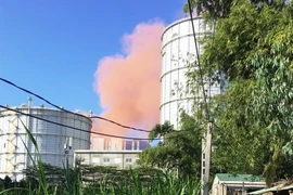 Khói bụi màu hồng phát tán ra môi trường, ngay sát khu vực dân cư sinh sống. (Ảnh: Phước Ngọc/TTXVN)