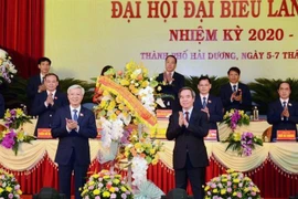 Ủy viên Bộ Chính trị, Bí thư Trung ương Đảng, Trưởng Ban Kinh tế Trung ương Nguyễn Văn Bình tặng hoa chúc mừng Đại hội. (Ảnh: Mạnh Minh/TTXVN)