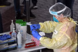 Nhân viên y tế xét nghiệm COVID-19. Ảnh minh họa. (Ảnh: AFP/TTXVN)