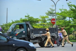 Các chiến sỹ Cảnh sát giao thông thành phố Ninh Bình đẩy xe giúp người dân khi sẩy ra sự cố. (Ảnh: Minh Đức/TTXVN)