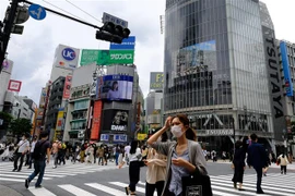 Người dân đeo khẩu trang phòng lây nhiễm COVID-19 trên một đường phố ở Tokyo, Nhật Bản. (Ảnh: AFP/TTXVN)