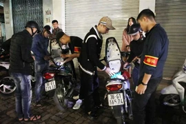 Lực lượng cảnh sát liên ngành 141 tiến hành kiểm tra hành chính người điều khiển xe máy vi phạm giao thông trên đường Đại Cồ Việt, Hà Nội. (Ảnh: Doãn Tấn/TTXVN)