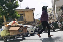 Trong nắng nóng người phụ nữ này vẫn tiếp tục cuộc sống mưu sinh. (Ảnh: Thanh Tùng/TTXVN)