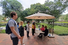 Du khách quốc tế thăm quan Văn Miếu trước ngày điểm đến này đóng cửa phòng dịch. (Ảnh: Bùi Huy Hoàng/Vietnam+)